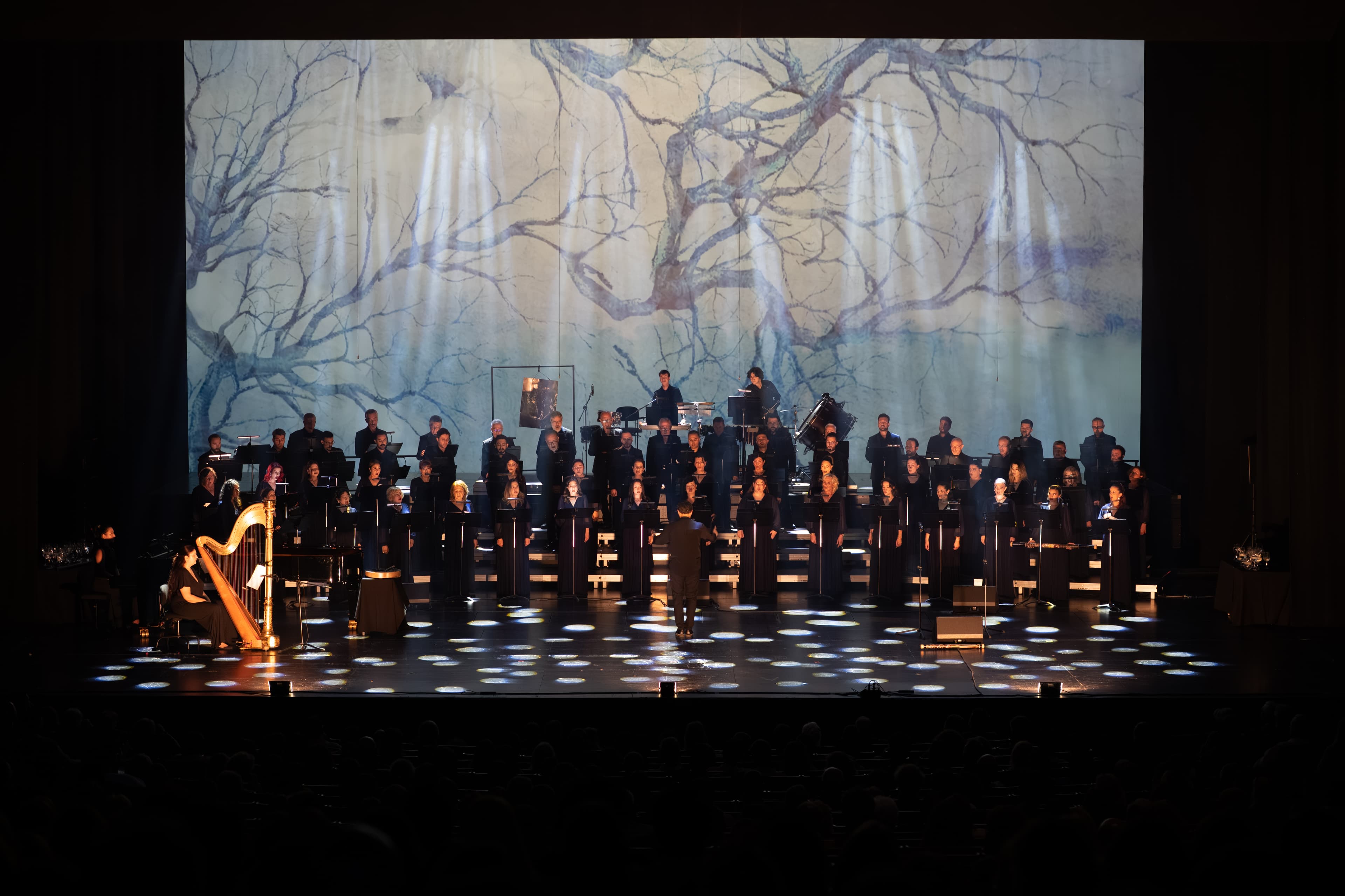 Aurora stage image with large-scale scrim projection across the ensemble