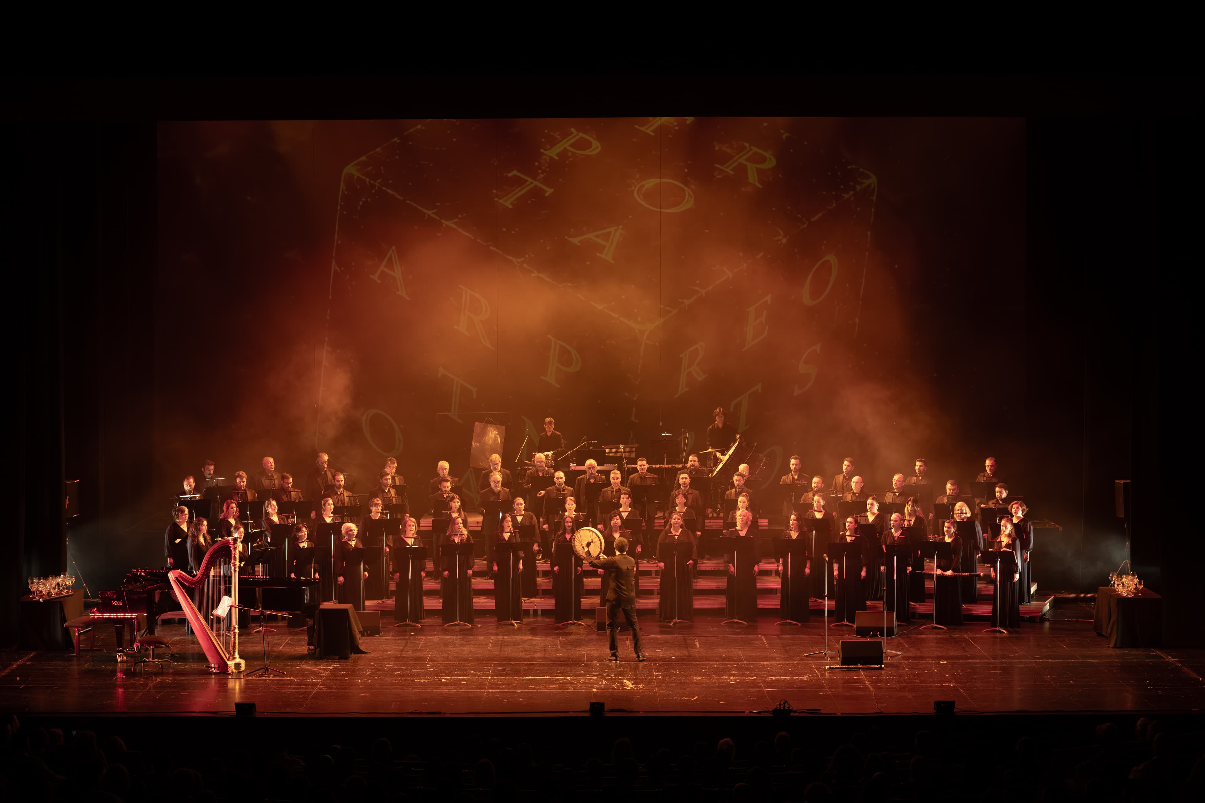 Aurora stage image with warm-toned projection architecture framing the chorus