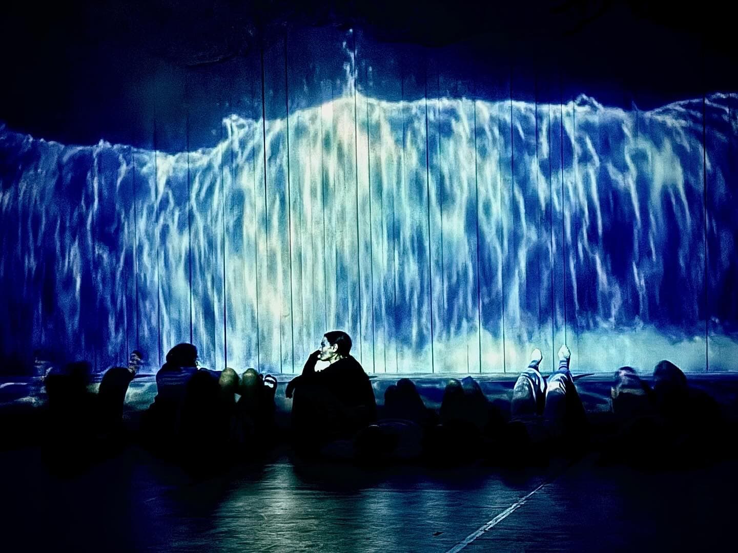 A Trojan Tale rehearsal scene with a large-scale blue wave projection